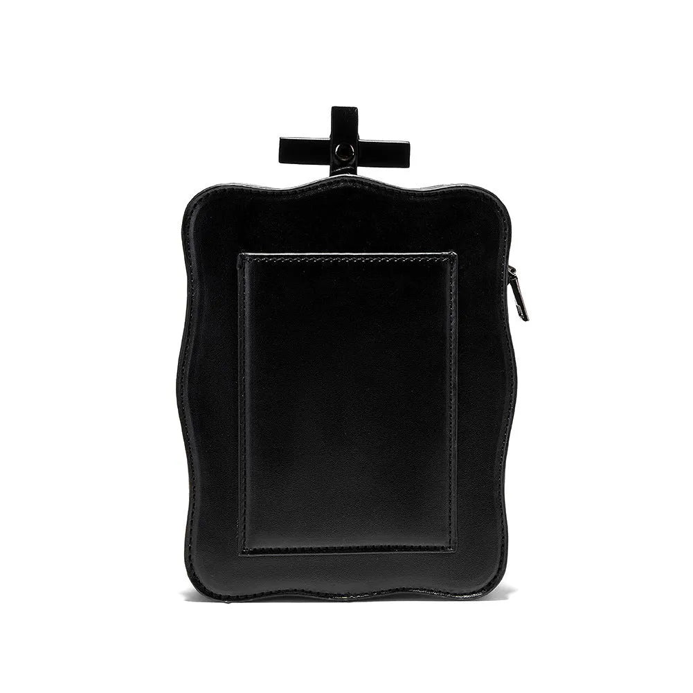 Black vertical square crossbody bag with embossed skull design, chain strap, and metal rivets.