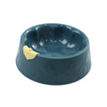 Green plastic double pet bowl for cats and small dogs on a floor.