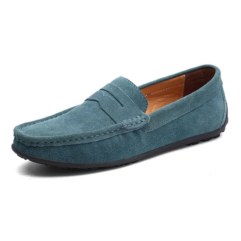 Men's suede leather Gommino loafers in black on a flat rubber sole, showing round toe and sewing line detail.