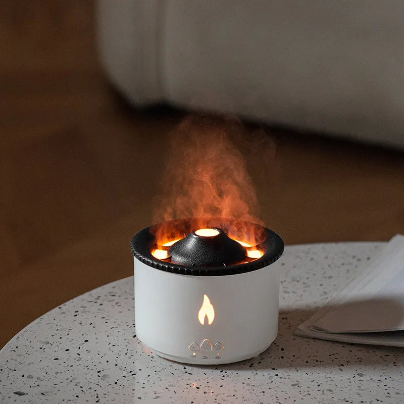 White flame and blue volcano humidifier diffuser with remote control on a table