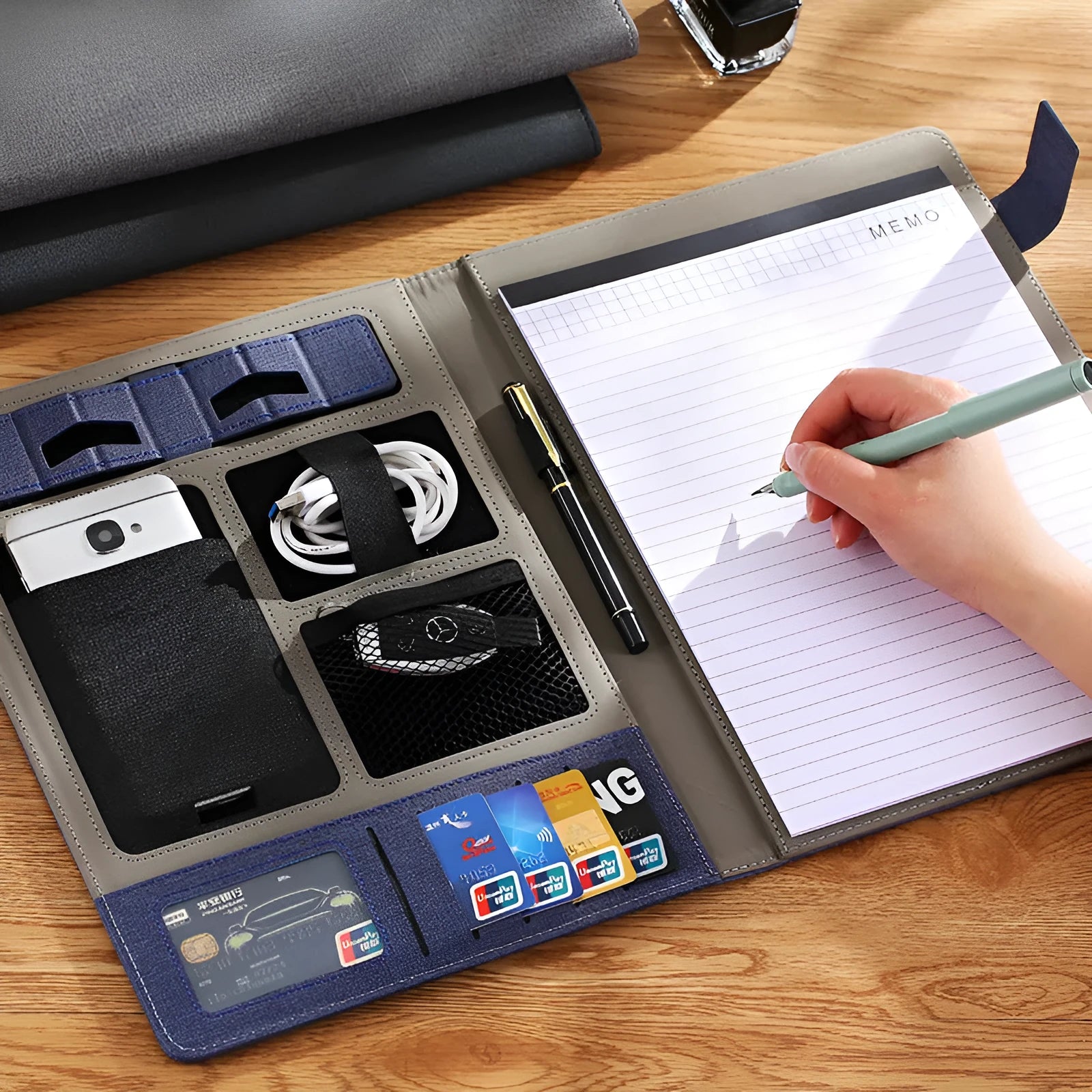 Black leather A4 business folder open, showing interior document space, pen loop, and optional notepad.