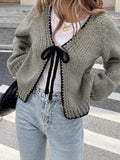 Lace-up cardigan sweater with crocheted flower detailing in solid colour