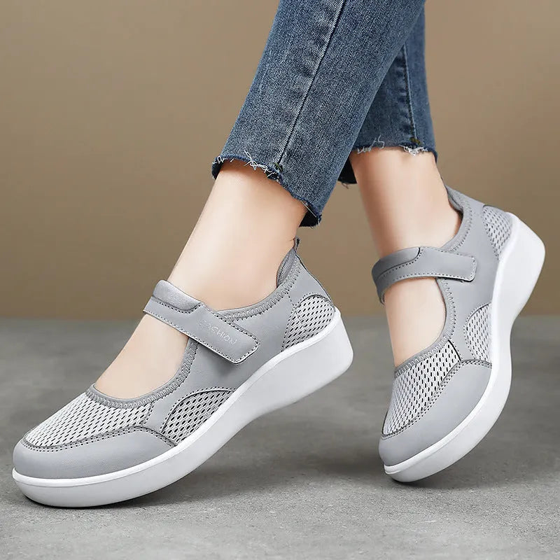 Women's low-top grey mesh casual trainers with Velcro fastening and a flat polyurethane sole.