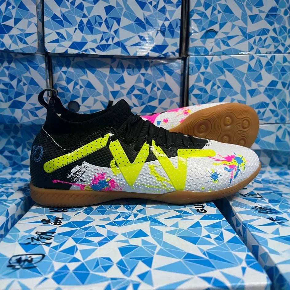 Low-top black and yellow football trainers with a spiked rubber sole and mesh detail.