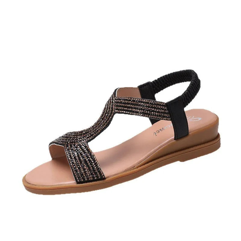 Women's gold patent leather beach sandals with rhinestones on a round toe, showing non-slip sole.
