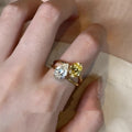 Copper geometric open ring with double zircon stones in a water drop design on a person's finger.