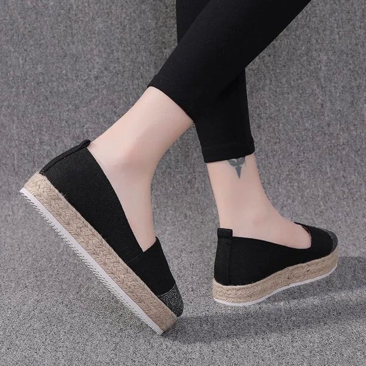 Beige and black women's canvas flat shoes with round toe and slip-on design.