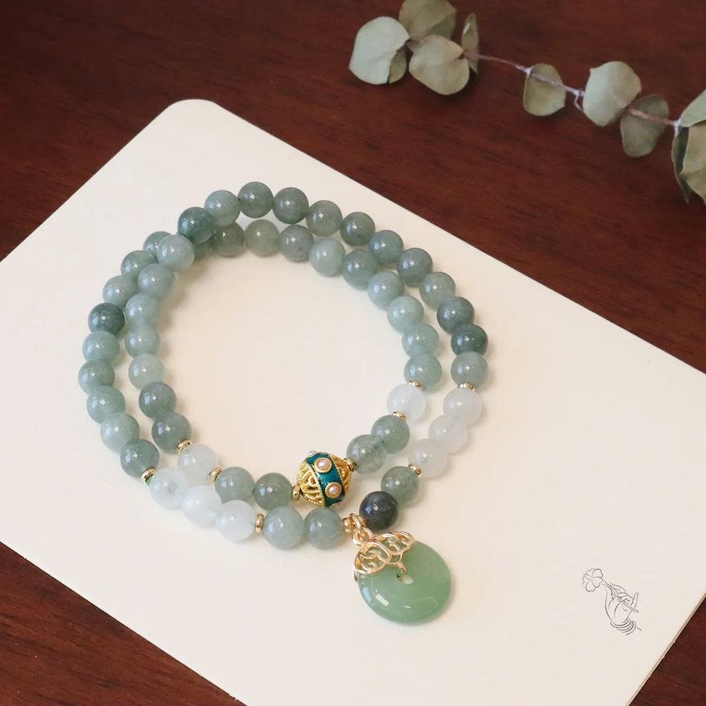 Close-up of a women's Myanmar jade bracelet with a geometric safety buckle pendant and lucky beads.