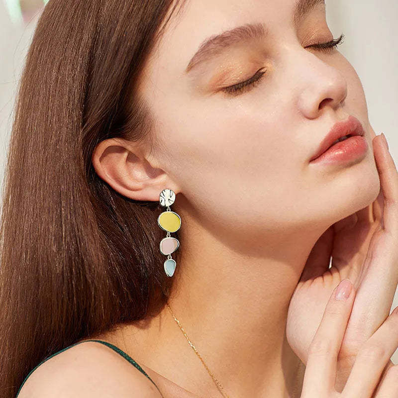 Sterling silver alloy Morandi three-colour oil drip simple wafer disc earrings on a white background.