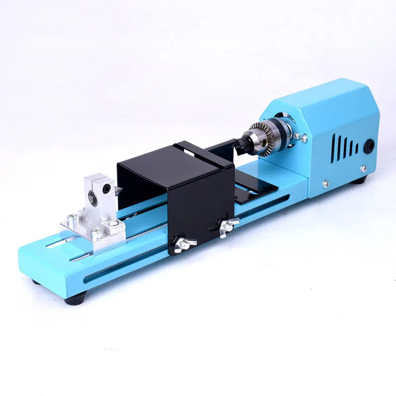 Mini woodworking lathe in blue with steel chuck, drill bit, and protective cover on a desktop