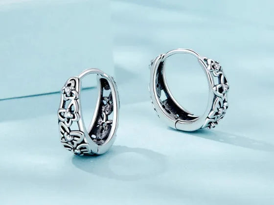 Close-up of retro hollow butterfly shaped stud earrings in sterling silver with zircon stones.