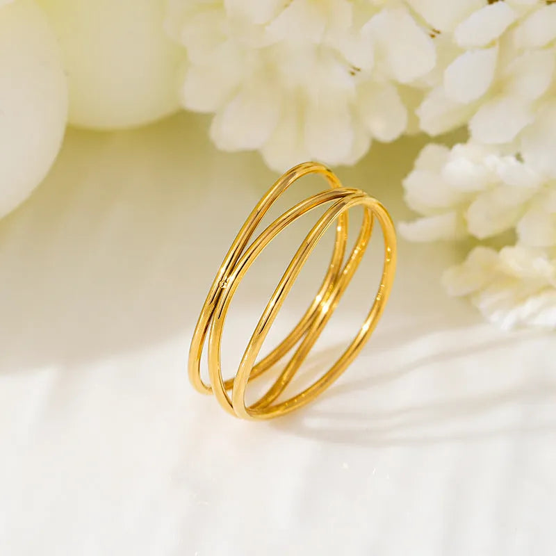 Gold-coloured titanium steel ring with a three-layer geometric coil band design.