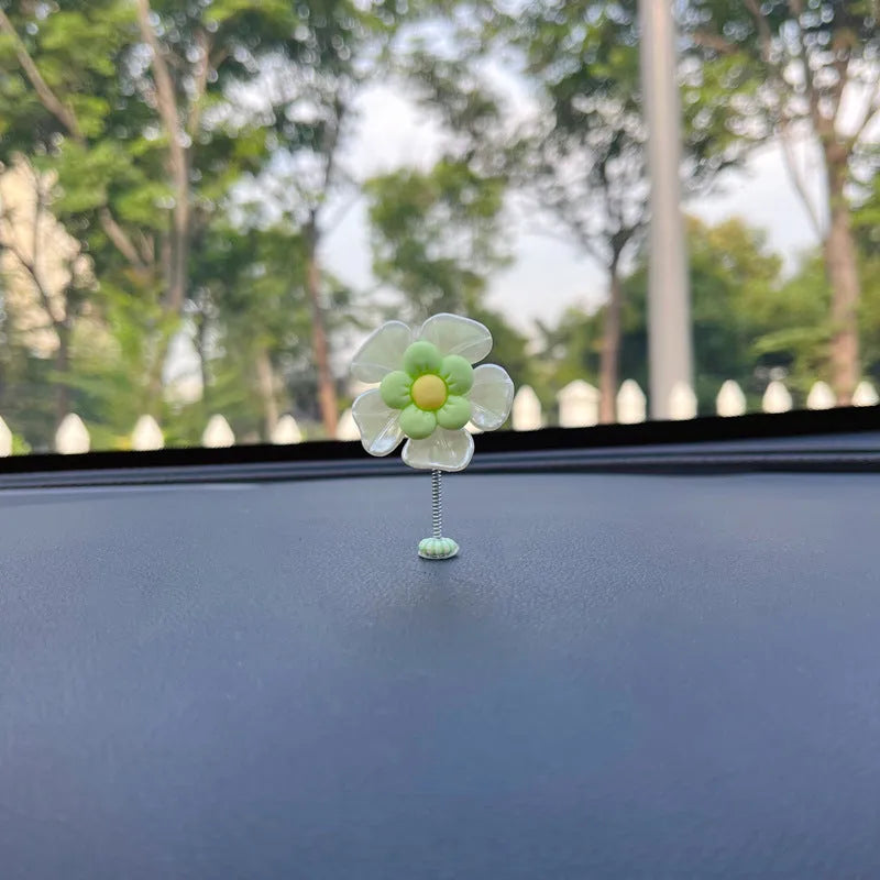 Small colourful plastic swing ornament for car dashboard, shown in blue, green, pink, purple, and yellow.