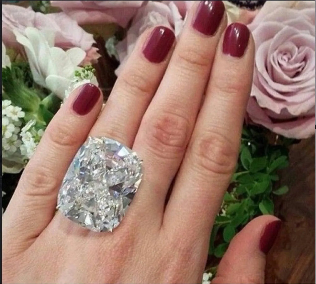 Women's simple square diamond ring in white gold colour on a hand, showing geometric band.