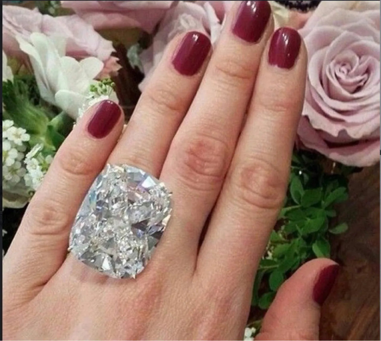 Women's simple square diamond ring in white gold colour on a hand, showing geometric band.