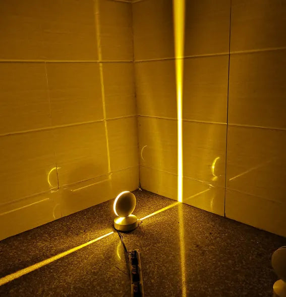 Modern aluminium LED bar wall lamp with glass lens, shown in a corridor setting.