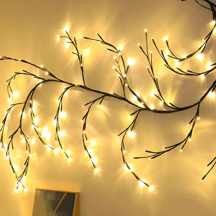 Flexible plastic willow vine LED garland light with warm white bulbs and birch bark texture.