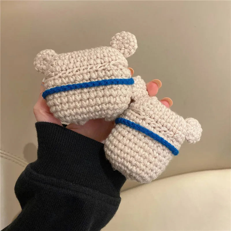 Hand-knitted grey koala bear backpack design earphone cover for Apple AirPods on a table.