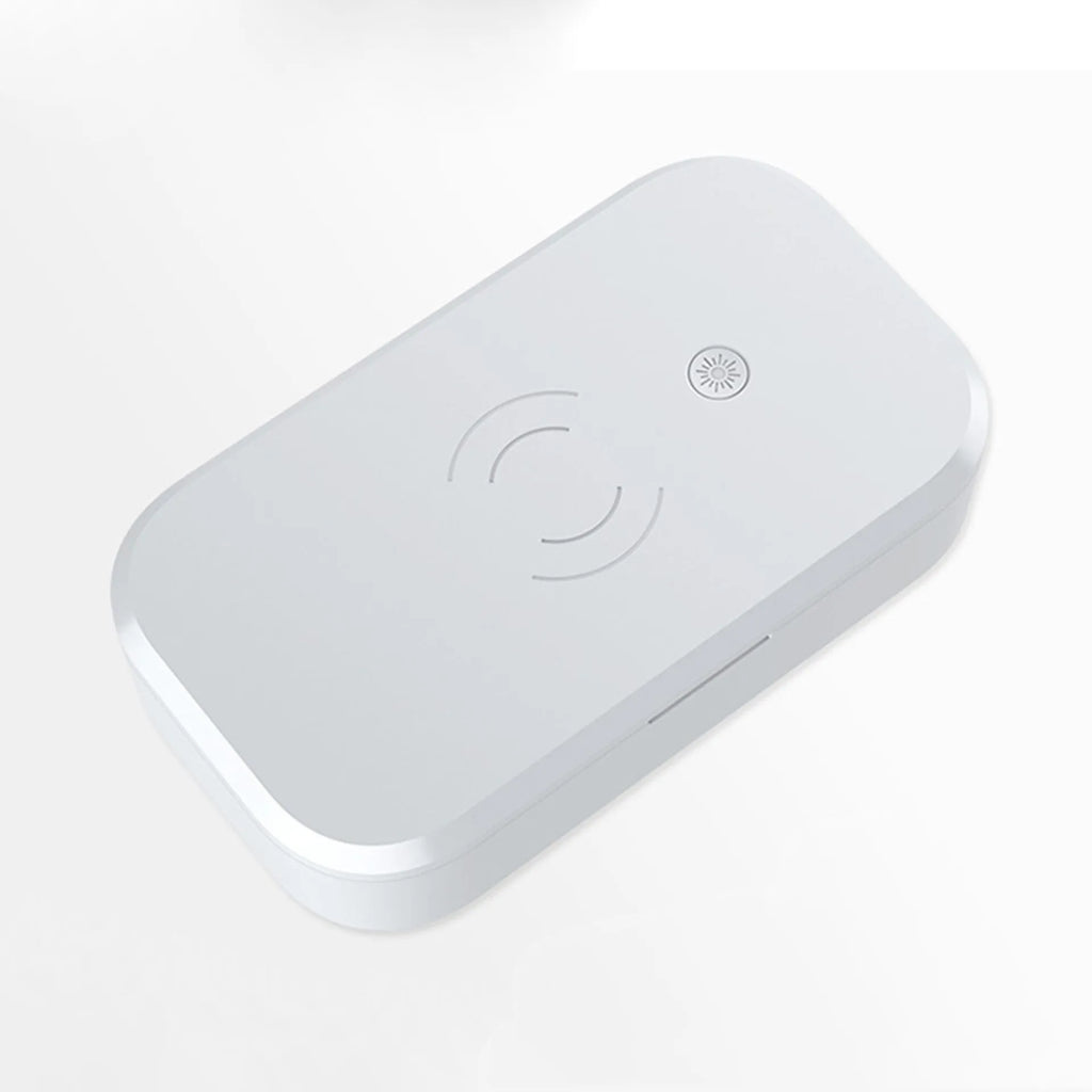 White ultraviolet disinfection box with wireless charging pad for mobile phones and beauty tools.