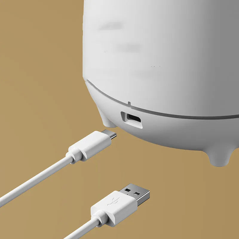 White volcanic-shaped ultrasonic humidifier and aromatherapy diffuser with USB cable on a table.