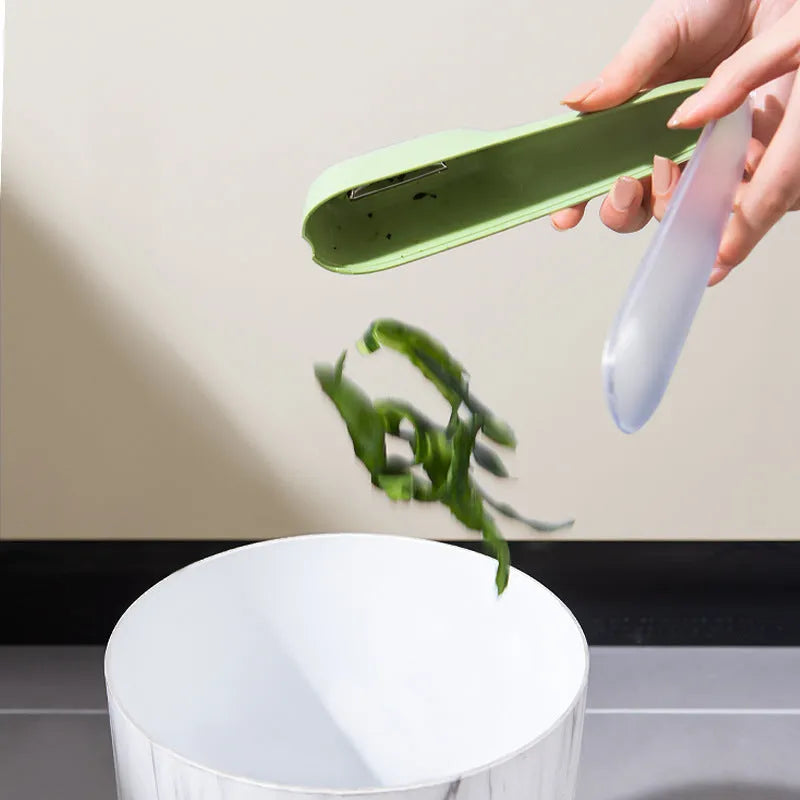 Green fruit and vegetable peeler with a stainless steel blade, plastic handle, and a separate white storage tube.
