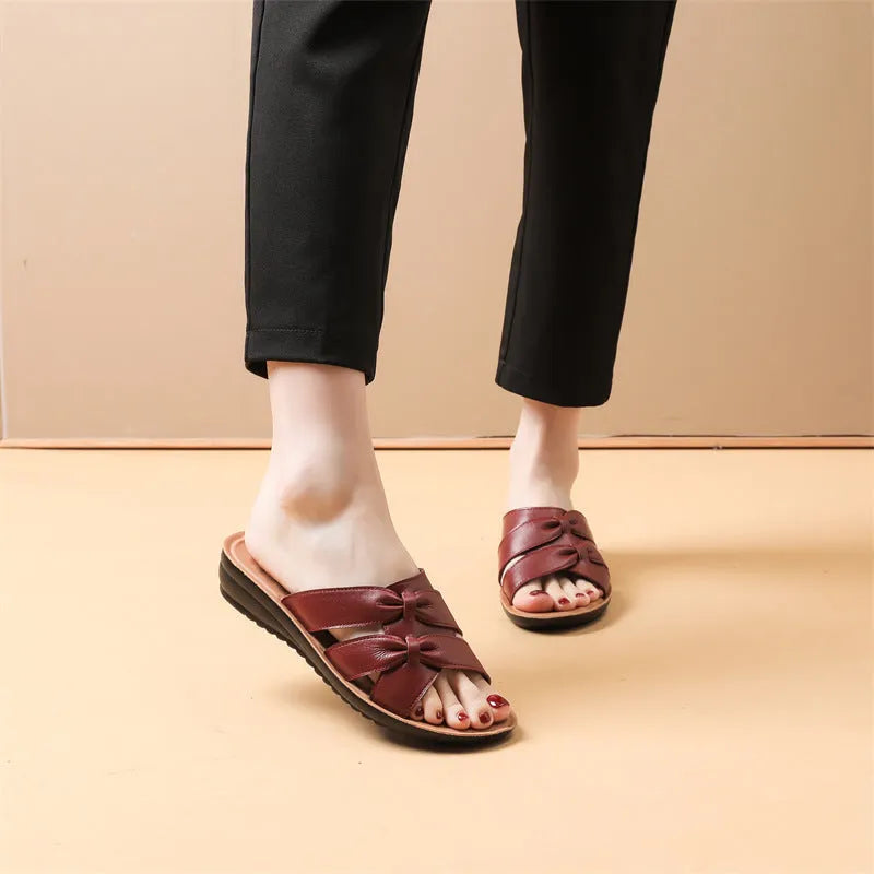 Beige women's cowhide slippers with a soft non-slip sole on a plain background