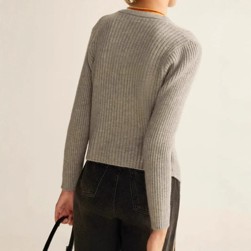 Red loose-fit cardigan sweater with a yarn collar on a hanger