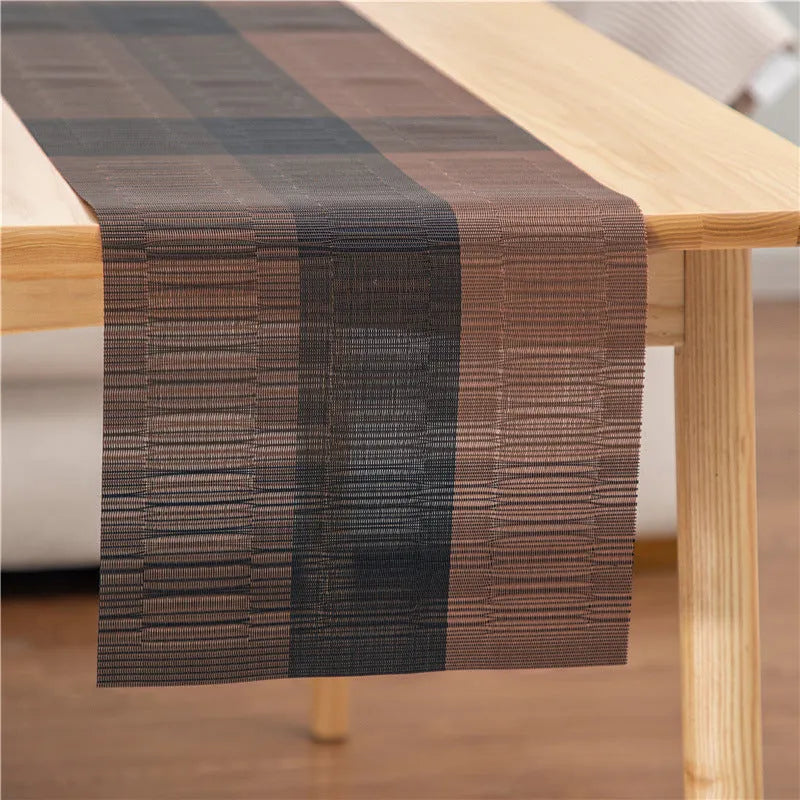 Modern non-slip PVC dish mat with gradient bamboo pattern in black, placed on a wooden dining table.