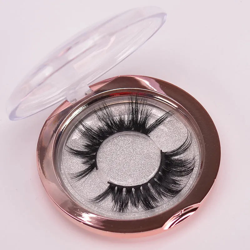 A pair of black 5D false eyelashes made from mink hair with an application brush and storage cap.