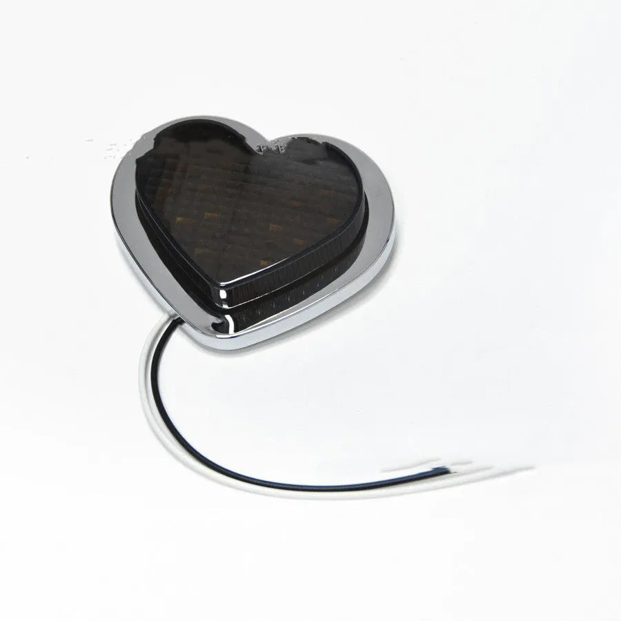 Heart-shaped red LED car fender sidelight on a black background.