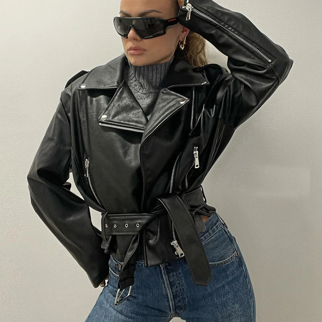 Black punk-style short jacket with a Peter Pan collar, lapel, and waist belt on a hanger.