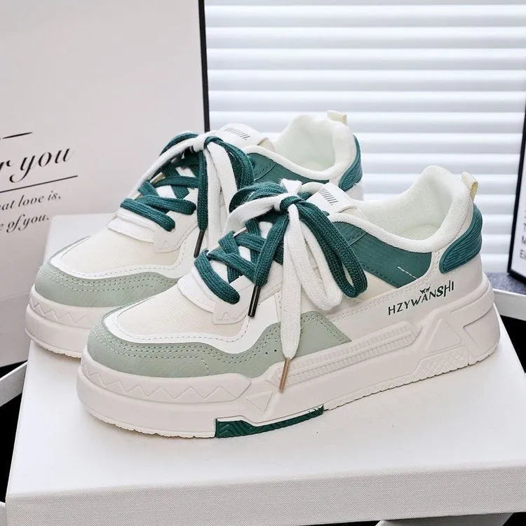 Beige children's lace-up trainers with cross straps over foot and thick rubber platform sole.