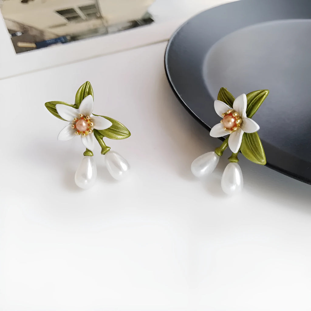 A pair of alloy flower earrings for women, showing sterling silver needle flower studs and a matching flower clip-on style.