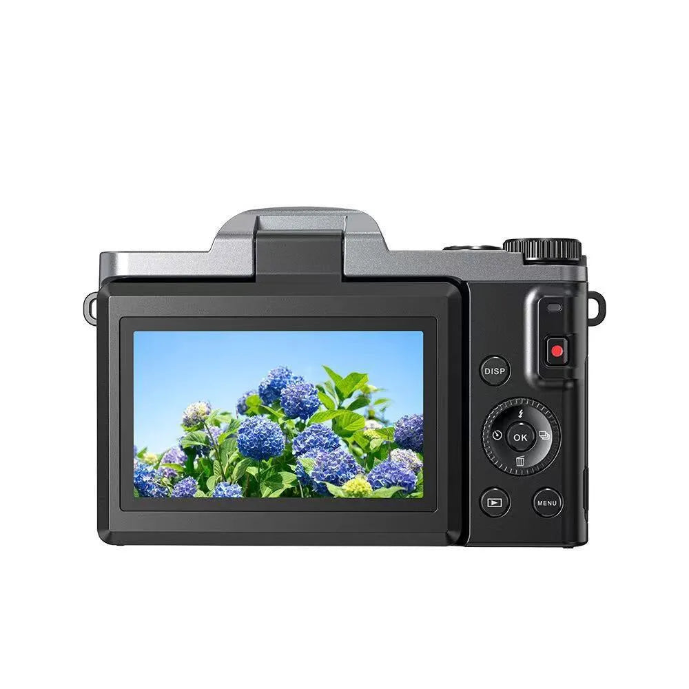 Black flip mirrorless digital camera resting on a cloth surface, showing its compact body and flip screen