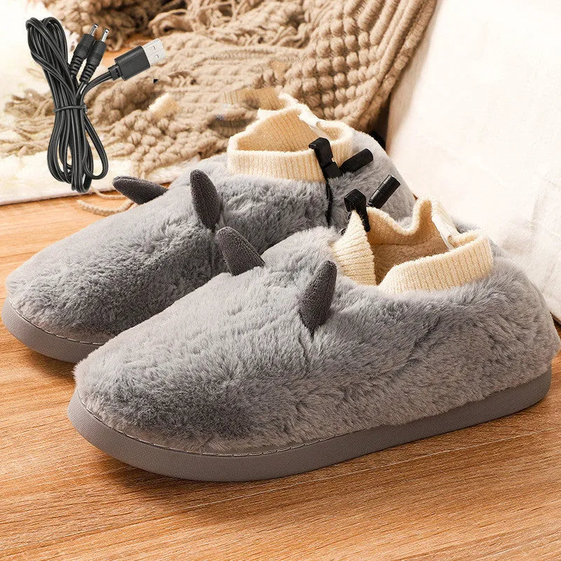 USB electric foot warmer slippers in grey with a connected USB cable on a wooden floor.