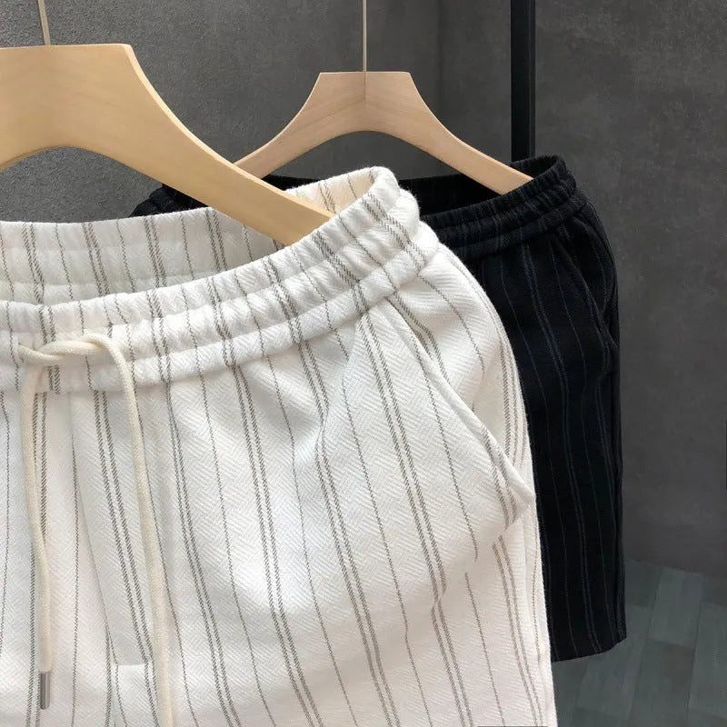 Men's black and white striped casual polyester shorts with an elastic waistband.