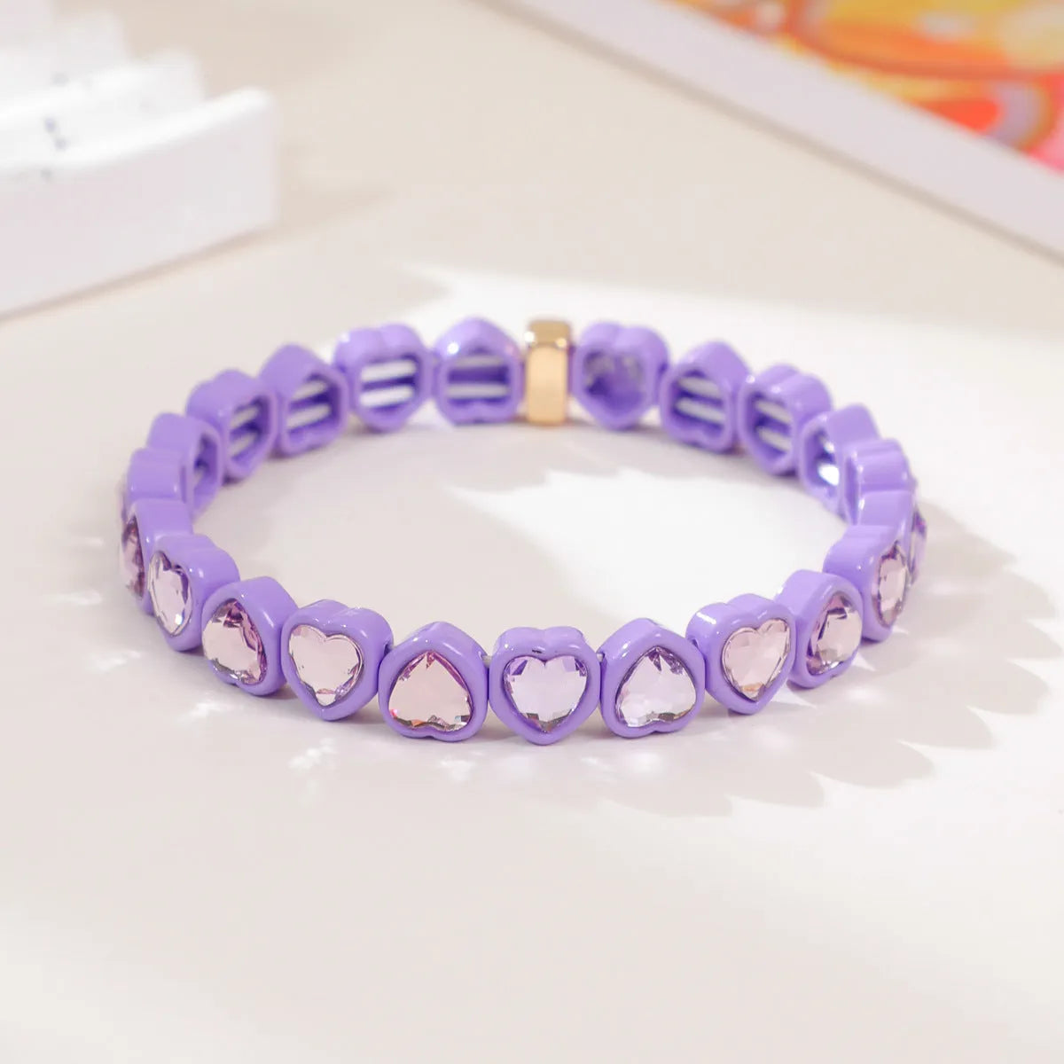 Rainbow enamel heart charm bracelet on alloy base with diamond treatment, stretch band, multicolour design.
