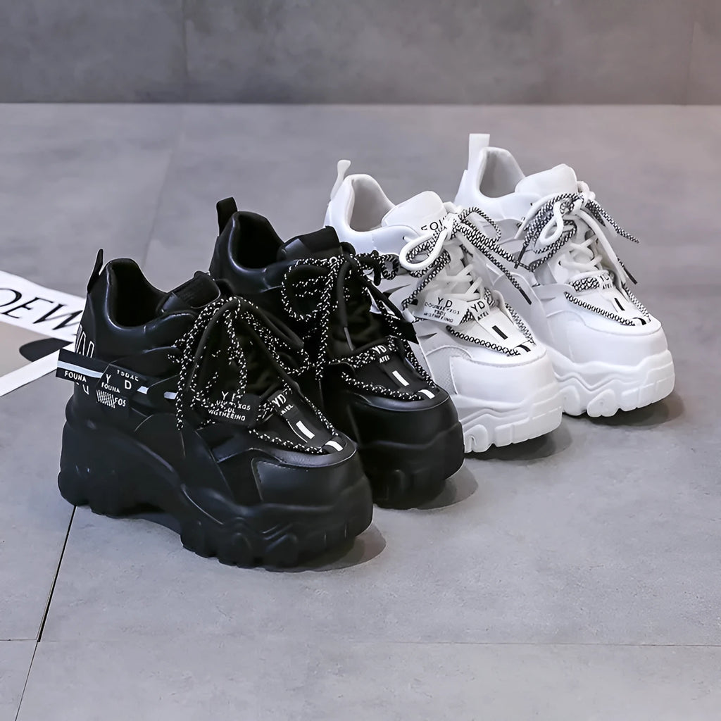 White women's low-top platform sports shoes with cross-strap detail on a rubber sole.