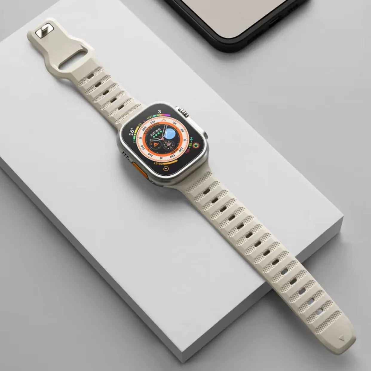 Black fluoro rubber Apple Watch band with silver T-buckle on a wrist, showing lightweight sport design.