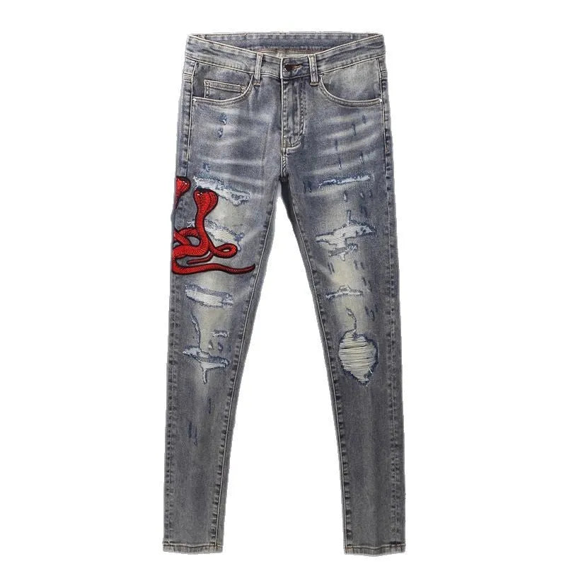Old colour slim fit jeans with washed-out finish, patch details, and embroidery on cotton fabric.