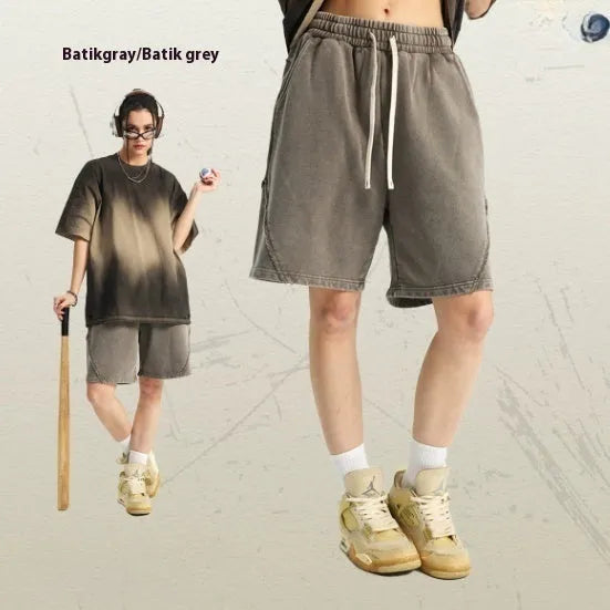 Man wearing batik-washed brown loose-fit cotton terry shorts on a casual street.