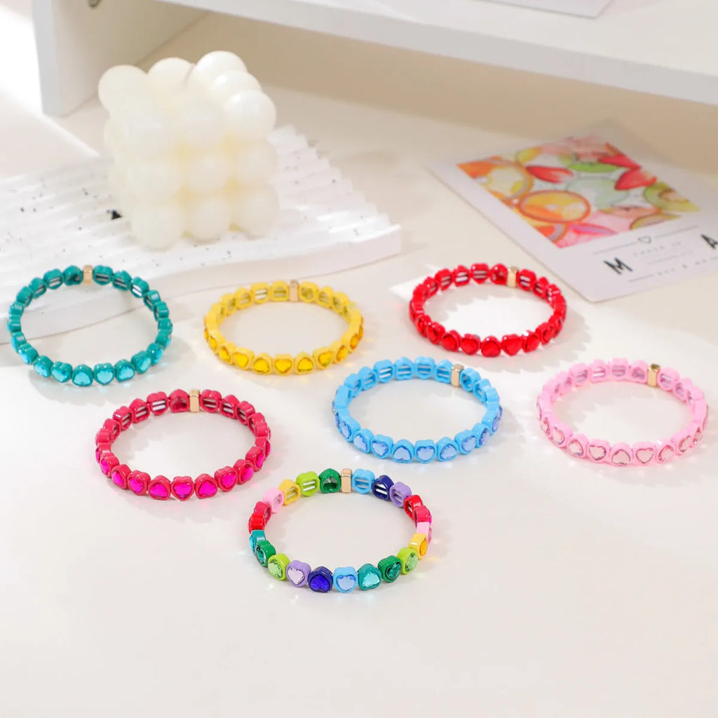Rainbow enamel heart charm bracelet on alloy base with diamond treatment, stretch band, multicolour design.