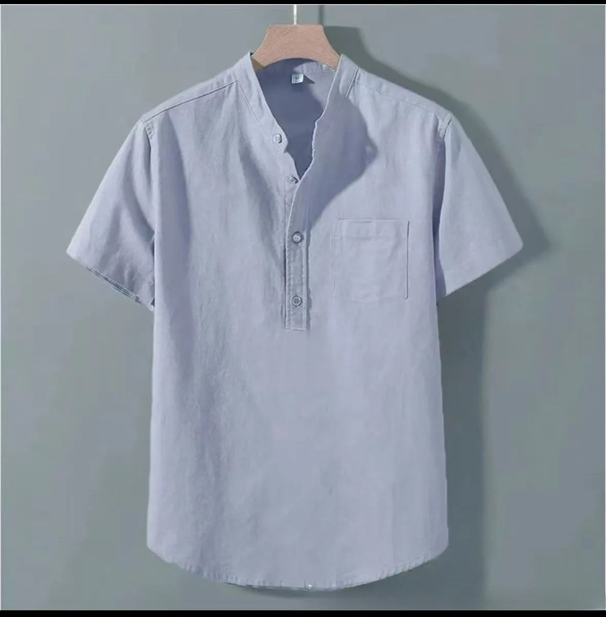 Man wearing a beige short sleeve linen and slub cotton casual shirt with a stand collar.
