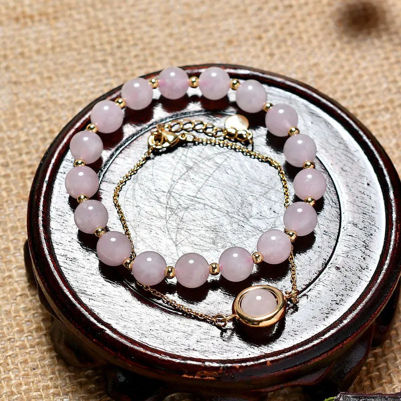 Close-up of a women's double-layer copper bracelet with lucky beads and an electroplated gold finish in a strawberry quartz colour.