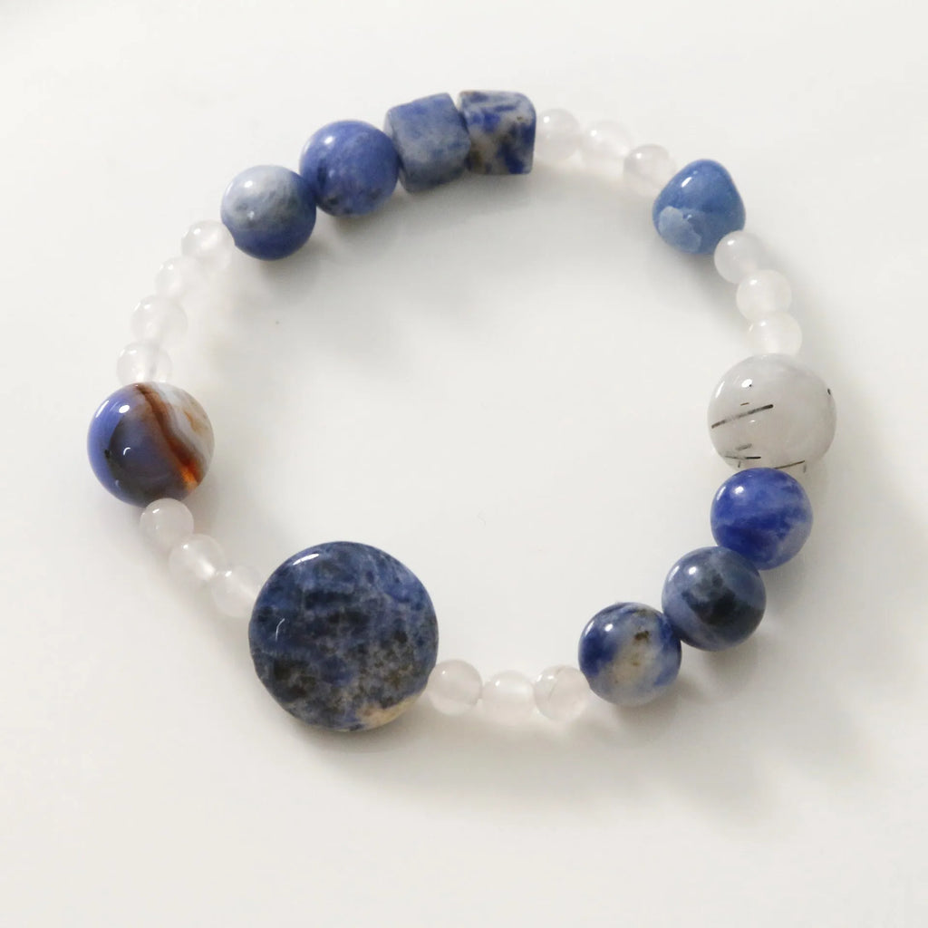 Hand-woven unisex bracelet with blue point stone and black hair crystal agate in a geometric design.