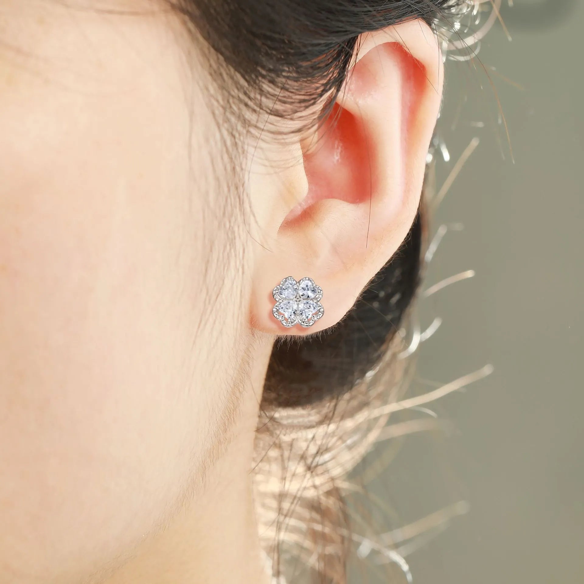 A pair of women's silver stud earrings with a four-leaf clover and heart design, white gold colour finish.