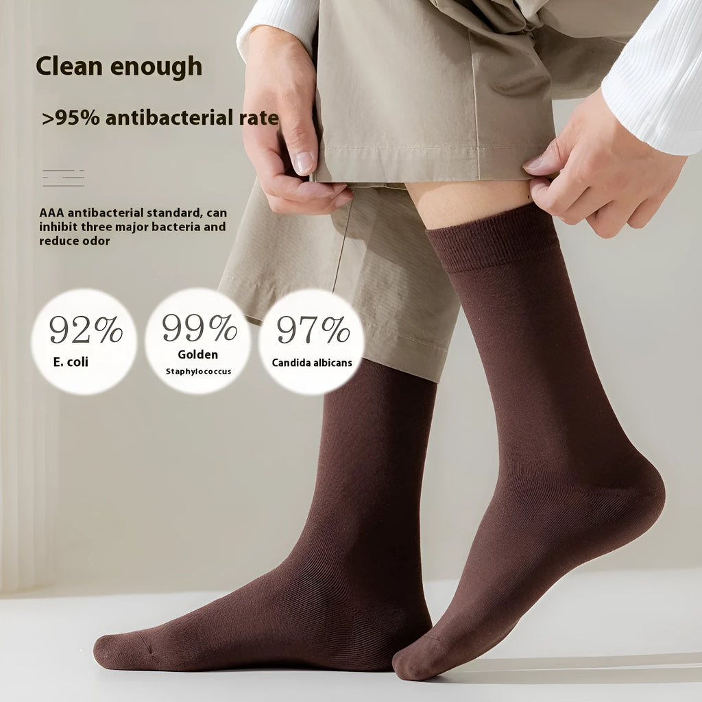 Five pairs of men's solid colour mid-calf socks made from combed cotton, shown in assorted colours.