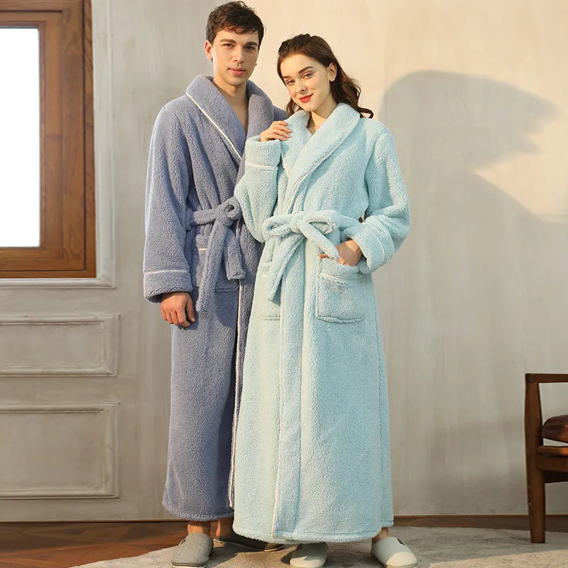 A man and woman wearing matching navy blue thick flannel bathrobes, showcasing the wrap-around design and plush fabric.