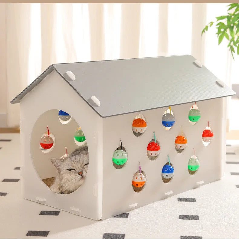 Durable plastic cat scratch board with an attached tunnel and a dangling bell ball toy on a neutral carpet.