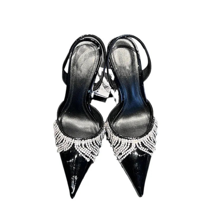 Black women's slingback high heel sandals with rhinestone and tassel decoration on a pointed toe.